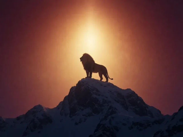 Un lion doré au sommet d'une montagne enneigée sous un ciel clair, l'éclat et l'ascension