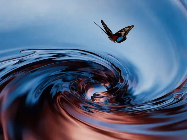 Un papillon volant au-dessus d'un tourbillon d'eau nocturne, la légèreté et l'intensité